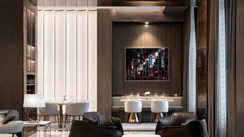 A dimly lit lounge area with leather chairs and tables. 
