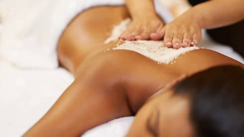 A young woman receives an exfoliating treatment at the spa