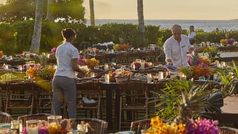 Four Seasons staff setting tables outside of Four Seasons Hawaii, Oahu at Ko Olinaat a Luau Dinner