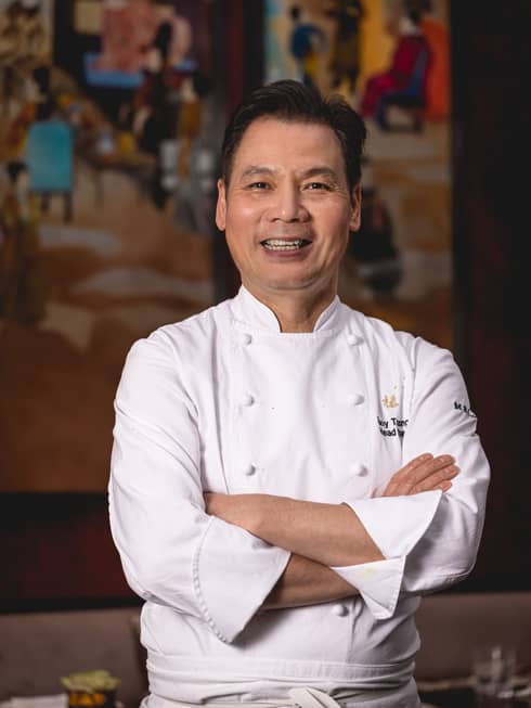 Chef Tony Truong in white chef's coat, smiling with arms crossed