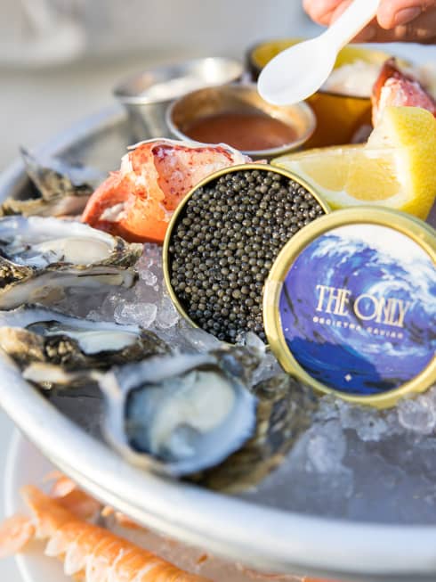 Caviar, Maine lobster, Shigoku oysters, seasonal crudos and jumbo prawns served on ice with lemon slices and small bowls of sauce