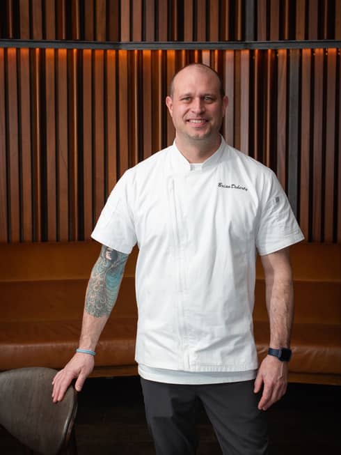 a male chef with a white chef coat on.