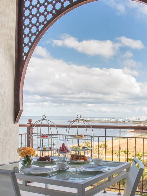 Balcony table with Afternoon Tea service, trays with pastries, sweets