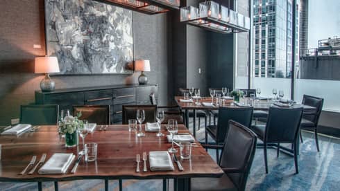 Goldfinch Tavern dining room with rustic wood table, grey chairs and decor