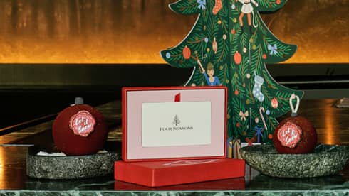 A gift card next to a small paper Christmas tree.
