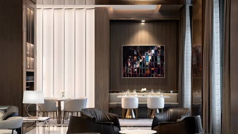 A dimly lit lounge area with leather chairs and tables. 