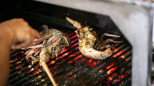 Seafood being cooked on a grill.