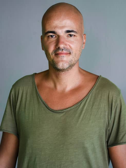 David Stojanovic wearing a green scoop-neck t-shirt
