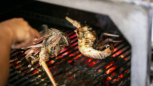 Seafood being cooked on a grill.