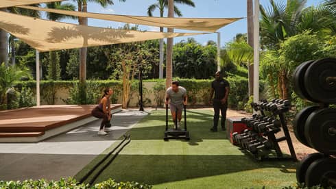 People exercising and lifting weights on an outside terrace