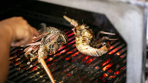 Seafood being cooked on a grill.