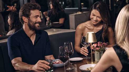 Three guests sitting at a dining table while talking and laughing.