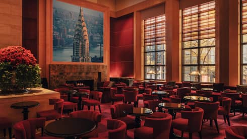 A spacious yet cozy lounge interior with upholstered seating, large windows and artistic decor