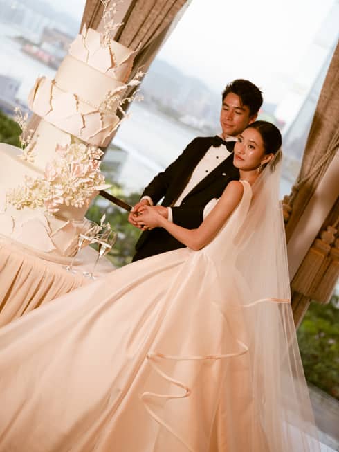 Bride and groom cut large wedding cake