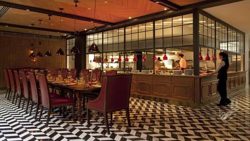 Elena is a warm dining atmosphere with black and white tiled floor and red accents 