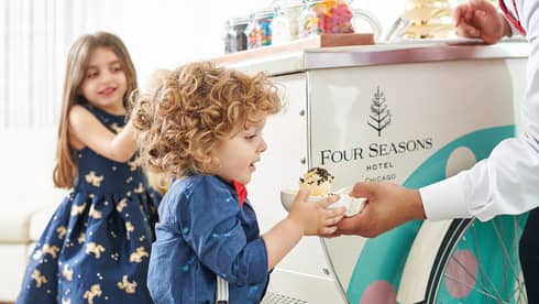 Two young guests getting ice cream from an ice cream cart.
