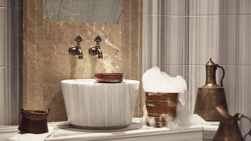 A luxurious sink and golden bucket with bubbles.