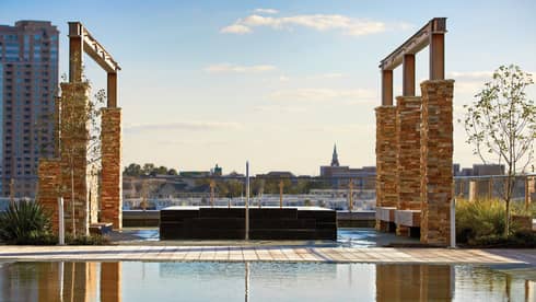 Tall brick pillars, frames over outdoor rooftop whirlpool and reflecting pool