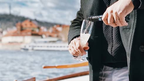 A man pouring a glass of wine on a boat.