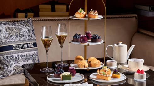 Christmas afternoon tea setup on square table beside banquette set with a black-and-white Christian Dior pillow