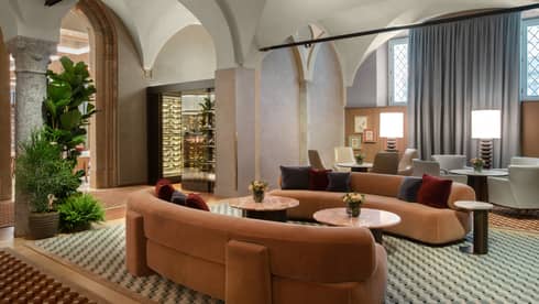 Lounge with two orange, velvet, curved sofas and checked floor