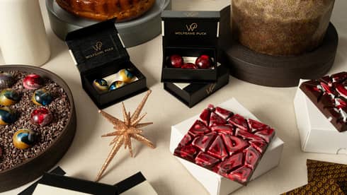Artful holiday desserts and chocolates in various black and white gift boxes