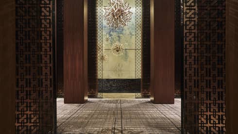 The interior lobby of FS Toronto, complete with bronze illusion walls, and dark oaky corridors.