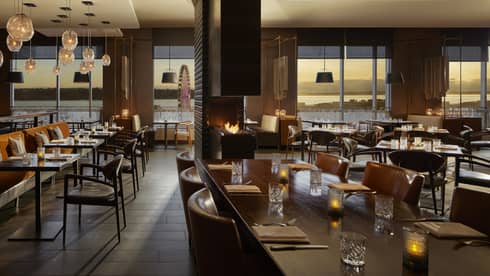 A dimly lit restaurant with large windows.