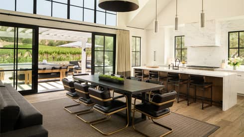 High-ceilinged kitchen and dining room of farmhouse-chic residence