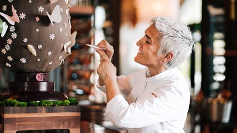 A chef decorates a giant chocolate egg