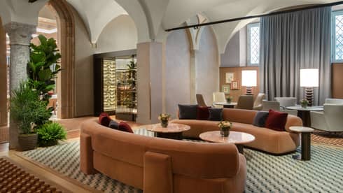 Lounge with two orange, velvet, curved sofas and checked floor