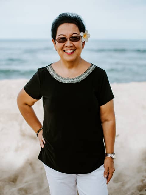 A portrait of a Four Seasons female staff member on the beach.