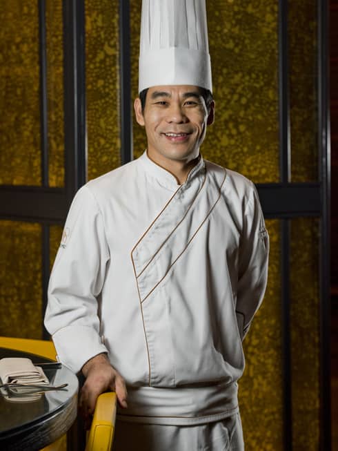 Chef from Four Seasons Hotel Doha stands near a dining table