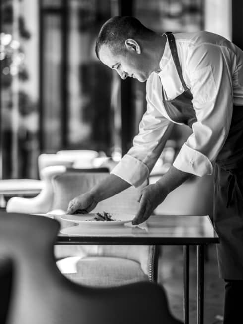 Shot of Chef Alan Taudon setting a plate on a table for two