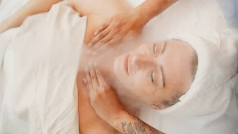A woman receiving a facial massage in a spa.