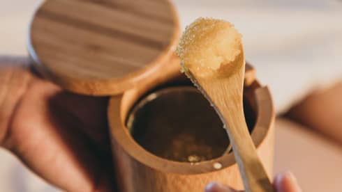 A spa staff member scoops some sugar scrub out of a bamboo container in Hawaii