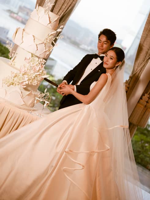 Bride and groom cut large wedding cake