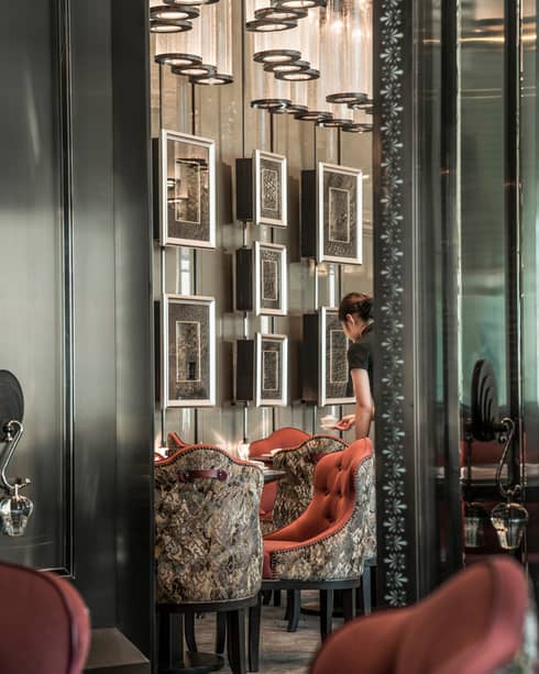 Yun House server sets a table with art on the wall in the background