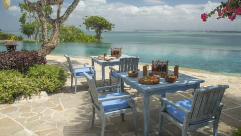 Alu Restaurant blue tables and chairs on flagstone patio directly on beach