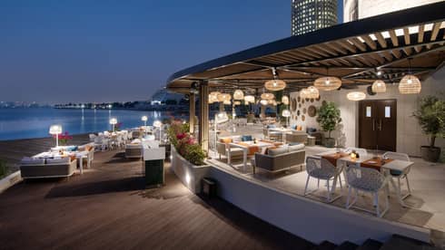 Makani Beach Club terrace overlooking the water at dusk