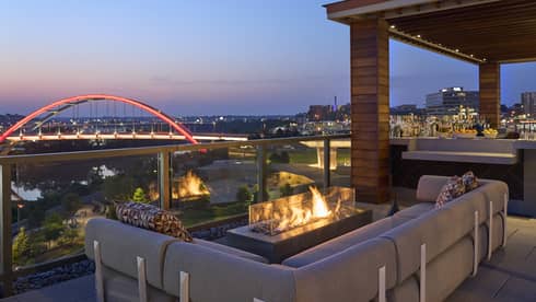 A fire pit by a sofa on a rooftop terrace.