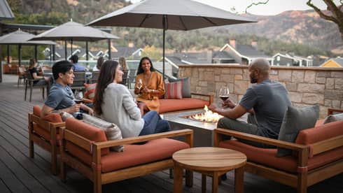 A group of people sitting outside with glasses of wine.