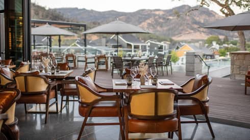Restaurant dining room opens to wooden patio with umbrellas
