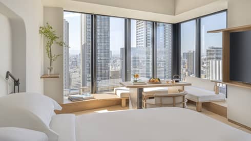 Luxurious guest room at Four Seasons Hotel Osaka with skyline views, modern decor, and serene seating area.