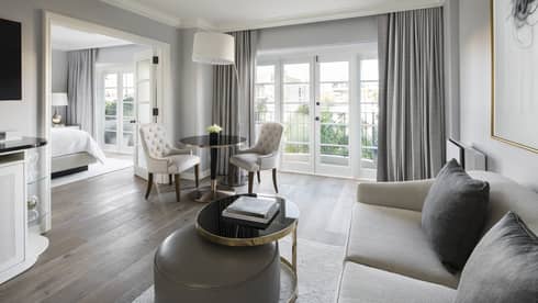 Deluxe Balcony Wellness Room bright living room sofa, table by balcony doors, French doors to bedroom