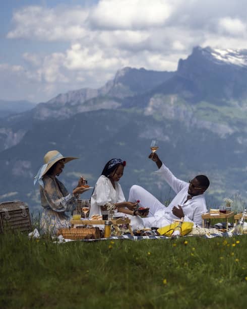 Three people enjoy gourmet picnic with ros� in French Alps