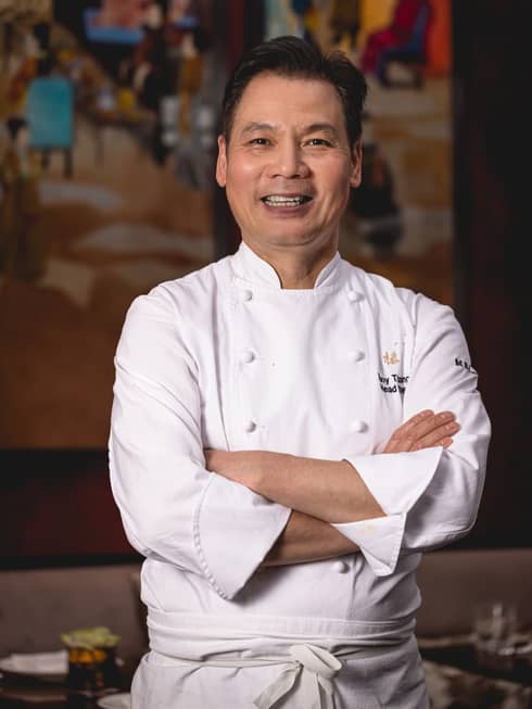 Chef Tony Truong in white chef's coat, smiling with arms crossed