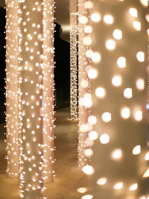 White columns covered in small white Christmas lights.