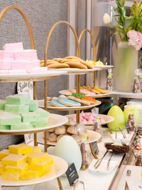 Display of desserts on a table with Easter eggs and flowers