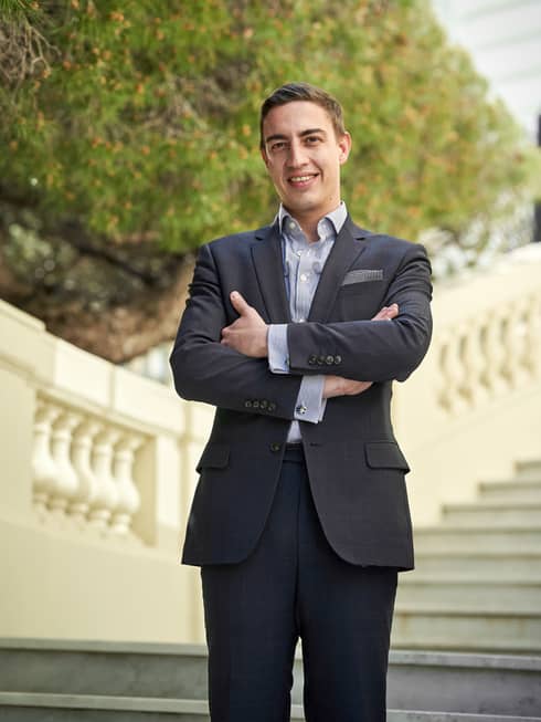 Head Sommelier Alessandro Nigro Imperiale with arms crossed, standing on grand staircase, smiling